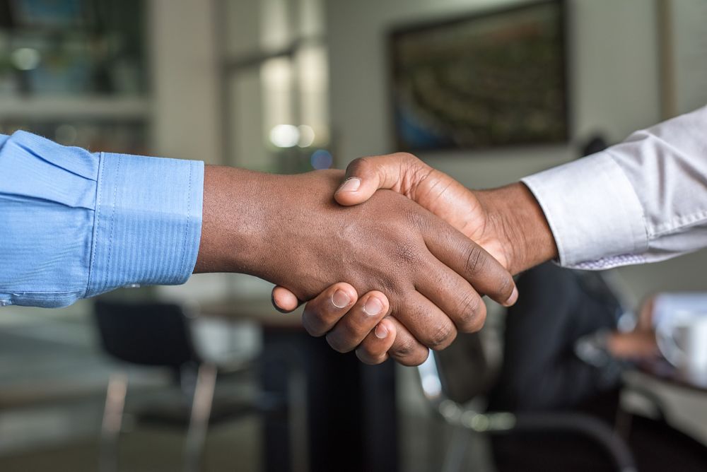 2 men shake hands after business deal