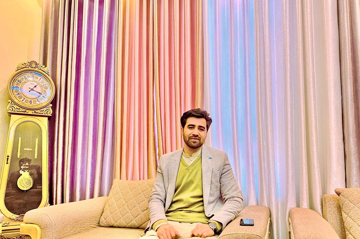 afghan man sat on sofa at home
