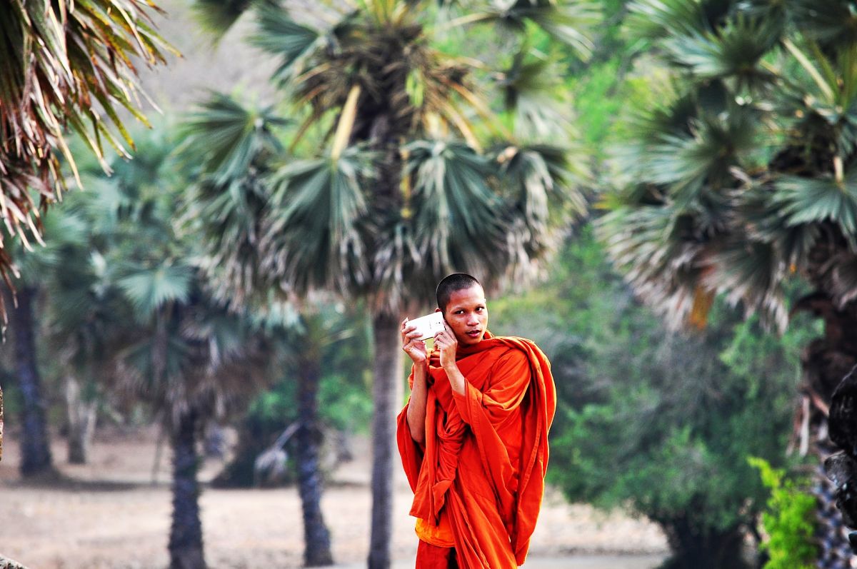 buddhist monk listens to smartphone