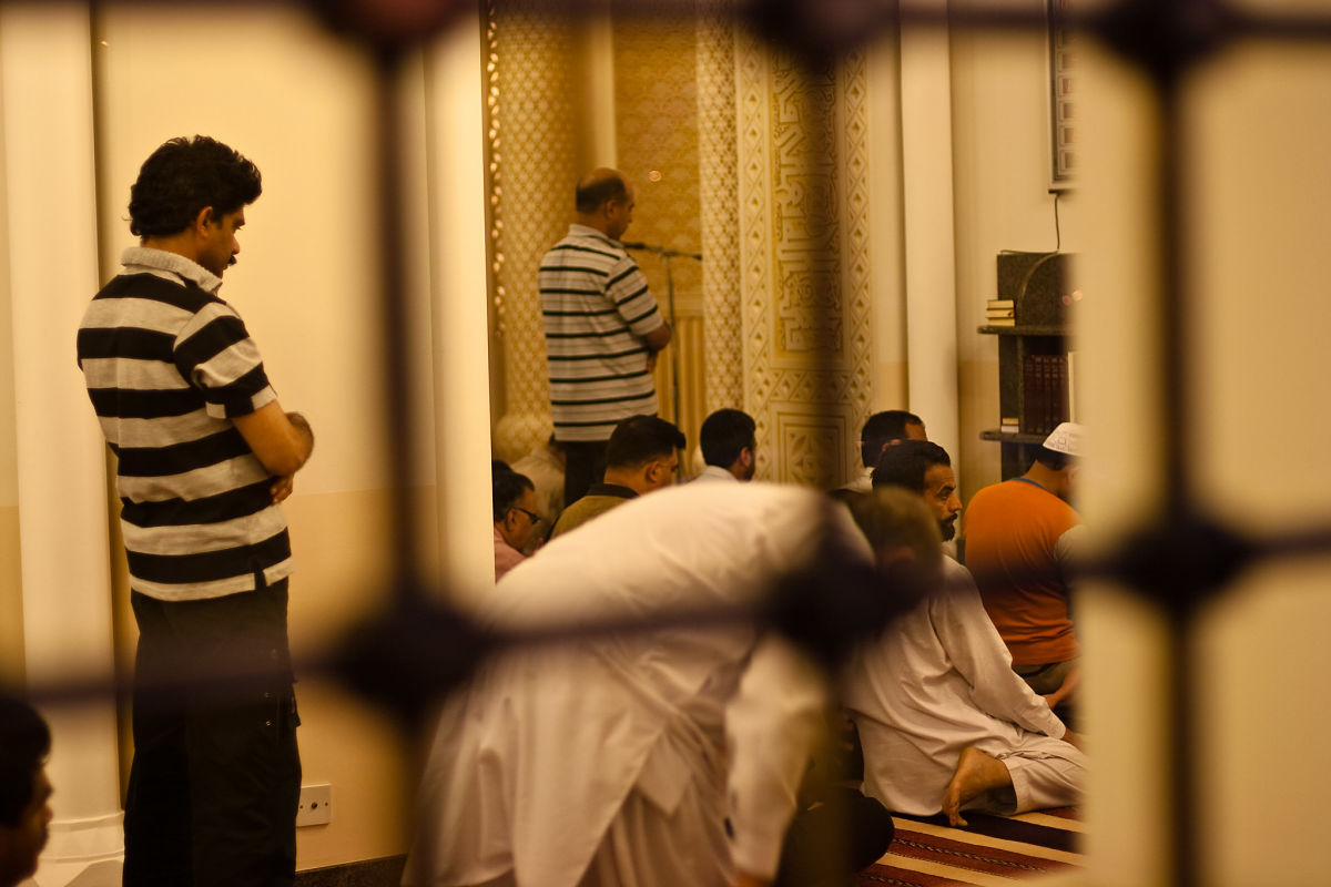 men praying manama