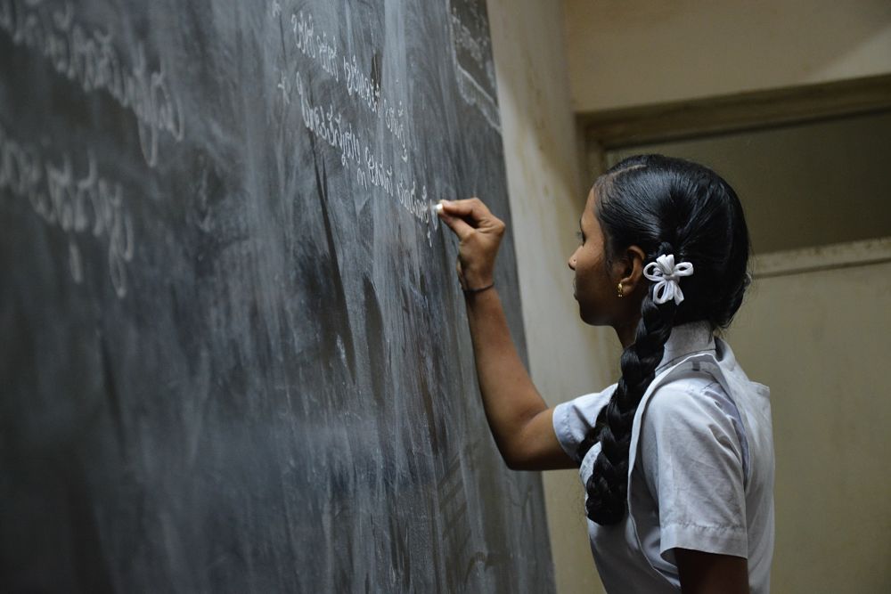 school girl in India with chalk
