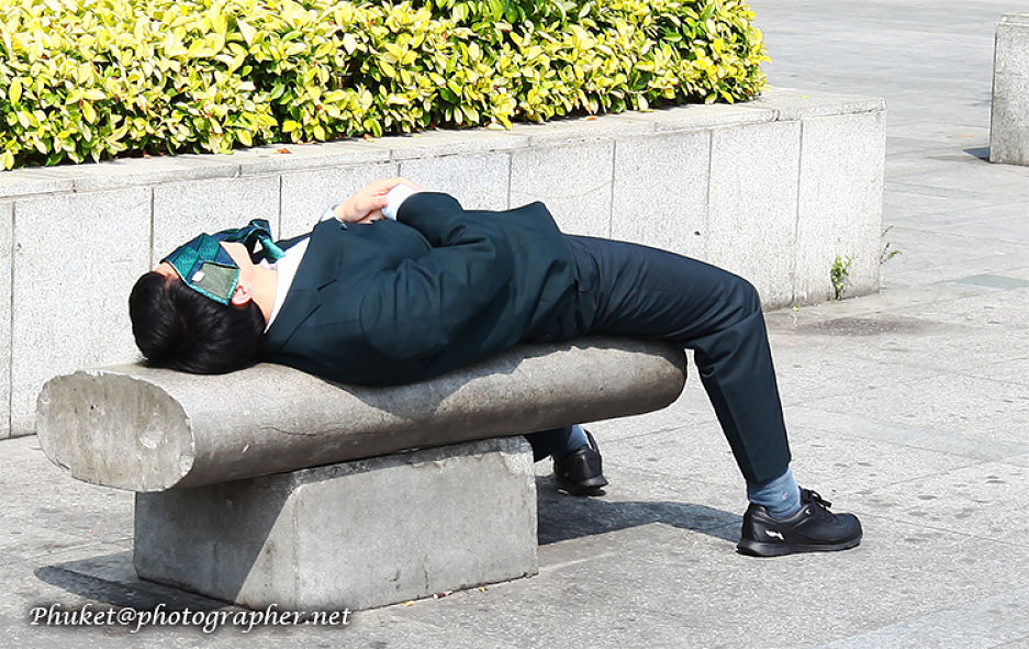 Thai businessman sleeping on bench