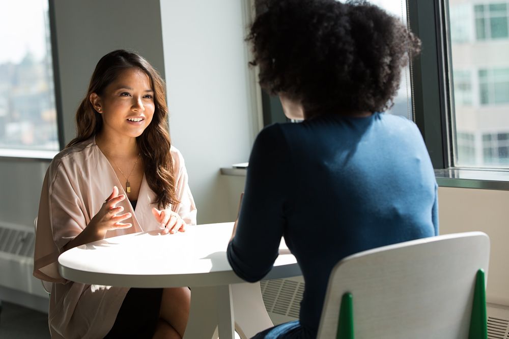 Two diverse business women at table